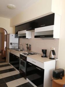 eine Küche mit einer schwarzen und weißen Arbeitsplatte in der Unterkunft Guest House SNG in Nessebar