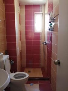 a bathroom with a toilet and a shower with red tiles at Guest House SNG in Nesebar