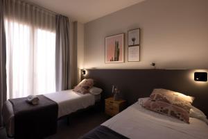 A bed or beds in a room at Apartamentos Turísticos Plaza del Rey by CartagenaSpain
