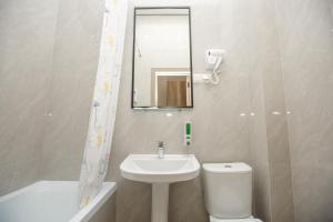 a bathroom with a sink and a toilet and a mirror at Отель Asyl in Astana