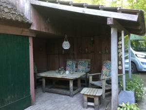 un patio con una mesa de madera y 2 sillas en FeWo am Ringkanal, en Ihlow