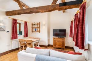 a living room with a couch and a tv and a table at Carters cottage in Buckinghamshire