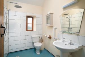 a bathroom with a sink and a toilet and a mirror at Carters cottage in Buckinghamshire