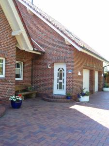 um edifício de tijolos com um pátio e uma porta em Ferienwohnung Haus Bikker em Ihlow