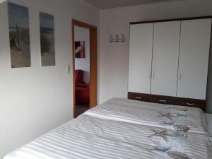 um quarto com uma cama com armários brancos em Ferienwohnung Haus Bikker em Ihlow