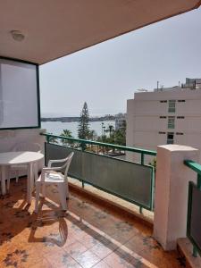 - un balcon avec une table et des chaises dans un bâtiment dans l'établissement COMODORO- RAVEL, à Los Cristianos