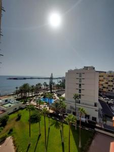 un edificio con un parque con palmeras y el océano en COMODORO- RAVEL en Los Cristianos