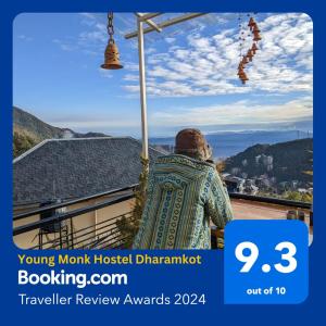 a person is looking out at the view from a house at Young Monk Hostel & Cafe Dharamkot in McLeod Ganj