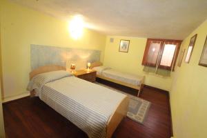 - une petite chambre avec 2 lits et une table dans l'établissement Quadrilocale Tanca Manna, à Cannigione