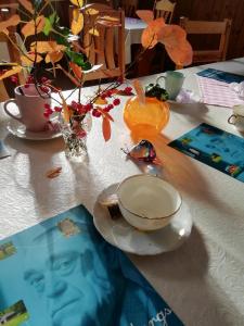 un tavolo con una tazza, una ciotola e un'arancia di Moshults Vandrarhem a Moshultamåla