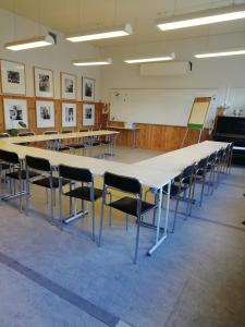 uma grande mesa e cadeiras numa sala de aula em Moshults Vandrarhem em Moshultamåla