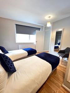 two beds in a room with a window at Kensington Private House- Walk to stores and tube-PRIVATE entrance- In Central London in London