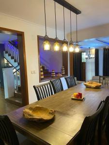 a dining room with a wooden table and chairs at Furnished House at Kibagabaga in Kigali