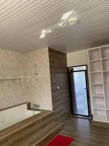 baño con bañera, lavabo y ventana en Furnished House at Kibagabaga, en Kigali