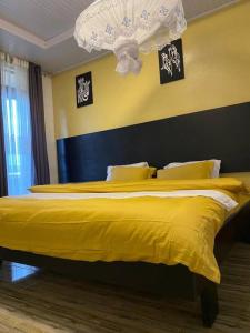 a bedroom with a large yellow bed with yellow sheets at Furnished House at Kibagabaga in Kigali