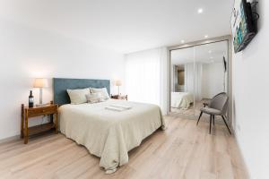 - une chambre avec un lit, une chaise et un miroir dans l'établissement GuestReady - Vacation family home near the beach, à Esposende