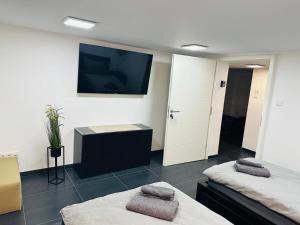 a room with two beds and a flat screen tv at Blauer Stein Apartments Doppelzimmer 2 in Pulheim