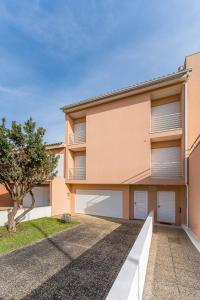 a building with two garage doors and a tree at GuestReady - Vacation family home near the beach in Esposende