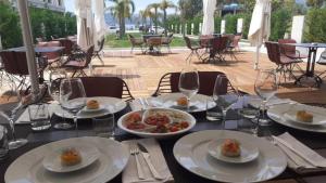 a table with plates of food and wine glasses at A&G HOTEL in Vlorë