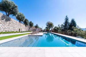 a swimming pool in front of a brick wall at GuestReady - Quinta Leitão 3 in Anissó