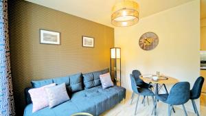 a living room with a blue couch and a table at Apartamenty Every Sky Szklarska Poręba, Żeromskiego 15c-5 in Szklarska Poręba +4 photos