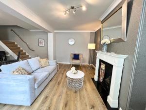 a living room with a couch and a fireplace at Kensington Private House- Walk to stores and tube-PRIVATE entrance- In Central London in London