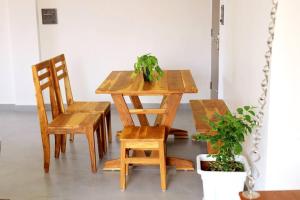 a wooden table and chairs with a plant on it at Eazy Homes in Palakkad