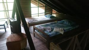 una habitación con 2 camas y un libro en el suelo en Acuali EcoHostal, en Capurganá
