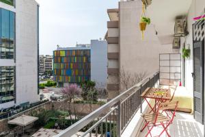 uma varanda com uma mesa e um edifício colorido em Modern Cosy Apt em Atenas