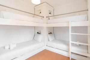 2 Etagenbetten in einem Zimmer mit weißen Wänden in der Unterkunft GuestReady - Marinhas Beauty near Esposende Beach in Esposende
