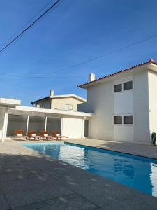 une maison avec une piscine en face d'une maison dans l'établissement GuestReady - Marinhas Beauty near Esposende Beach, à Esposende