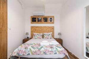 um quarto com uma cama e duas almofadas em GuestReady - Guimarães Urban Retreat em Guimarães