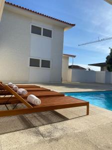 - une piscine avec une terrasse en bois à côté d'une maison dans l'établissement GuestReady - Marinhas Beauty near Esposende Beach, à Esposende