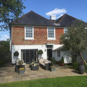 a brick house with a couch in a yard at Ingram House with Hot Tub in Hurst Green