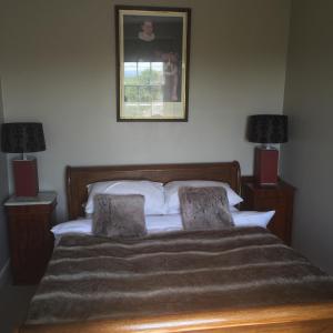 a bedroom with a bed with two lamps and a picture on the wall at Ingram House with Hot Tub in Hurst Green