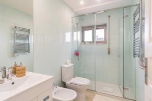 a bathroom with a toilet and a glass shower at GuestReady - Marinhas Beauty near Esposende Beach in Esposende