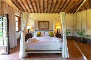 um quarto com uma grande cama branca com duas lâmpadas em Borgo San Luigi em Monteriggioni mais 77 fotografias