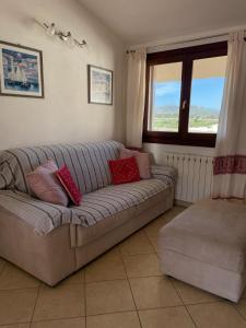 sala de estar con sofá gris y almohadas rojas en Flat Flumendosa 31, en Olbia