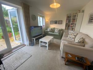 a living room with a couch and a tv at Bodmin Rest 4 U in Bodmin