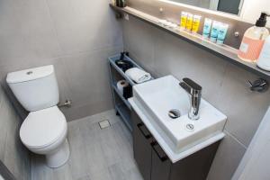 a bathroom with a white sink and a toilet at Brand New flat near Lycabettus Hill by Luckeys in Athens