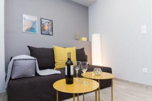 a living room with a couch and two tables with wine glasses at Brand New flat near Lycabettus Hill by Luckeys in Athens