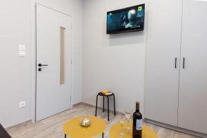um quarto com duas mesas e uma televisão na parede em Brand New flat near Lycabettus Hill by Luckeys em Atenas