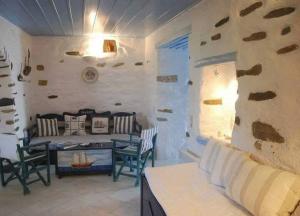 a living room with a couch and a table and chairs at Paros Traditional Nest Cozy Paroikia Delight in Parikia