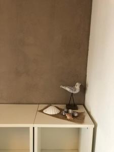 a table with a bird and shells on it at Vakantiehuis in Katwijk aan zee in Katwijk aan Zee