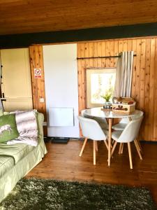 a living room with a table and a couch at Caban Cwtch in Cenarth
