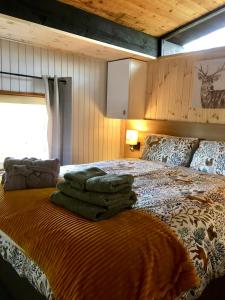 een slaapkamer met een bed met groene handdoeken erop bij Caban Cwtch in Cenarth