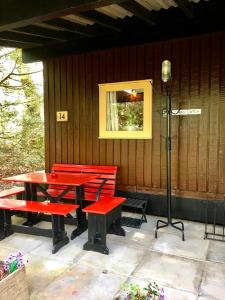 a picnic table and red benches on a patio at Caban Cwtch in Cenarth