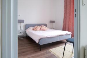 a bedroom with a bed with pink pillows on it at Bel appartement idéalement situé centre-ville Angers in Angers