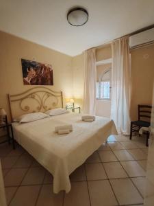 a bedroom with a large bed with two towels on it at Life Hotels Residence dei Baroni in Syracuse