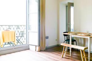a room with a table and chairs and a balcony at Bel appartement idéalement situé centre-ville Angers in Angers